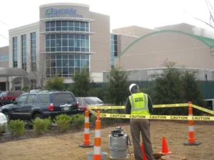 A man standing in front of a building with orange cones.